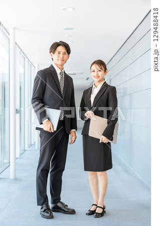 オフィスの廊下に立つスーツ姿の若いアジア人ビジネスマン男女 129488418