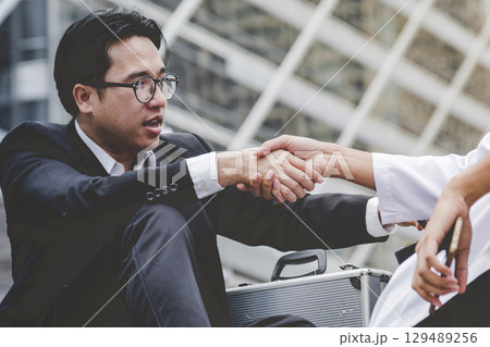 Arab Businessman shaking hands together. Teamwork business partner wear Muslim dress Shake Hands with Partnership Concept. Success UAE diversity people trust make commitment by handshake 129489256