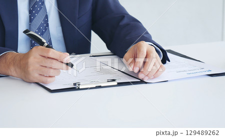 Businessman hands note meeting document in conference room. man Hands writing planning notebook. Close up male hand holding pencil write on diary sketchbook at office desk. Business Planning Concept Businessman hands note meeting document in conference room. man Hands writing planning notebook. Close up male hand holding pencil write on diary sketchbook at office desk. Business Planning Concept 129489262