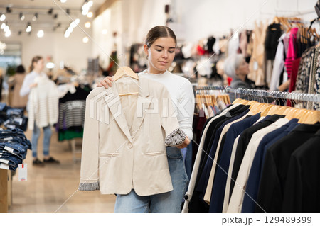 Young girl choosing convenient blazer in clothing store 129489399