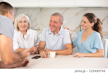 Family of four sits at table and talking 129489748