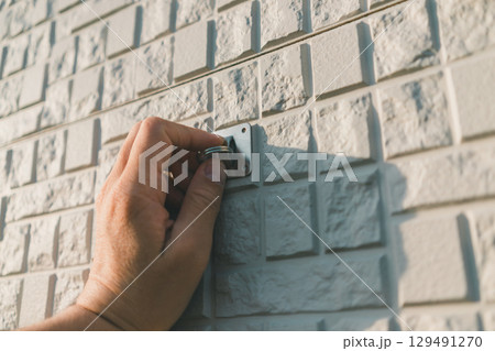 日よけシェードを固定する金具を家の外壁に取り付ける 日よけシェードを固定する金具を家の外壁に取り付ける 129491270