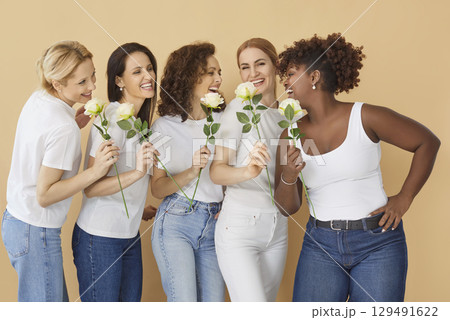 Woman Day celebration concept. Happy multi ethnic women pose with roses 129491622