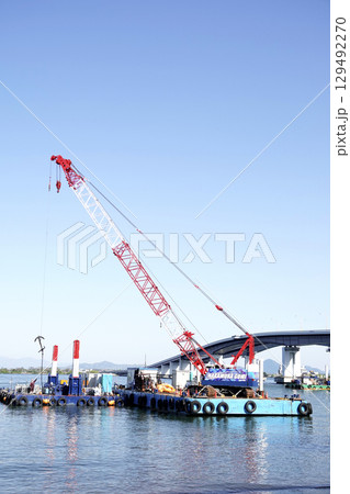 快晴の空の下b琵琶湖大橋と作業する起重機船 129492270