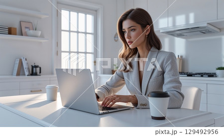 在宅ワークで資料作成を行う働く女性のデスク環境 129492956