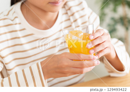 オレンジジュースを飲む中学生の女の子 オレンジジュースを飲む中学生の女の子 129493422