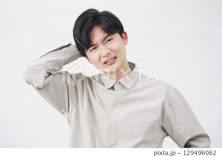 男性　20代　困る　白背景 129496062