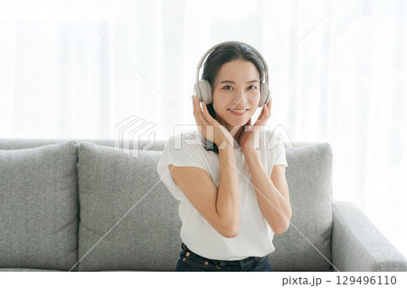 リビングで音楽を聴く女性 129496110