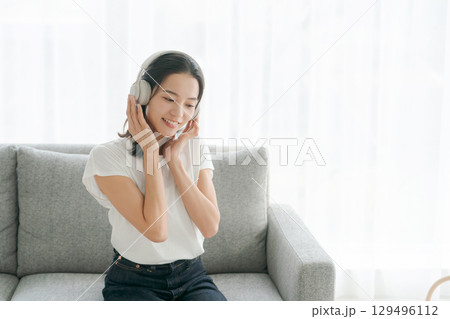 リビングで音楽を聴く女性 129496112