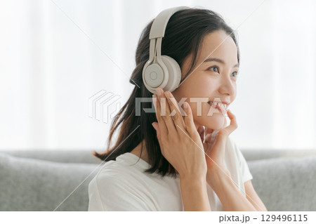 リビングで音楽を聴く女性 リビングで音楽を聴く女性 129496115