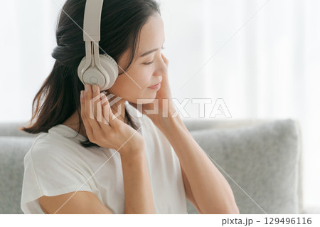 リビングで音楽を聴く女性 129496116