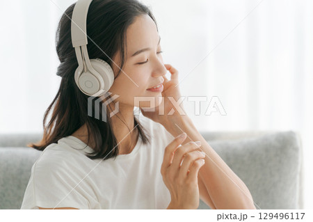 リビングで音楽を聴く女性 129496117