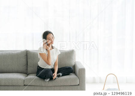 リビングで音楽を聴く女性 リビングで音楽を聴く女性 129496119