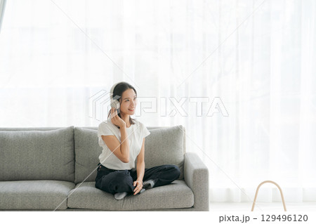リビングで音楽を聴く女性 129496120