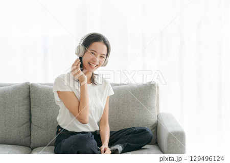 リビングで音楽を聴く女性 129496124
