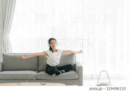 リビングで音楽を聴く女性 129496133