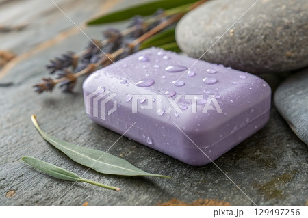 Purple Soap Bar with Water Droplets and Natural Elements on a Slate Surface 129497256