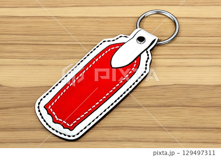 Bright Red Keychain Tag on Wooden Background for Stylish Organization and Labeling 129497311