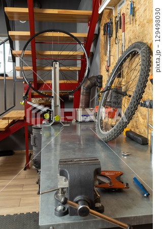 Modern workshop with metal tabletop, bike tools 129498030