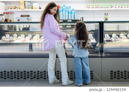 Young mom with daughter shopping for ice cream in modern cafe Young mom with daughter shopping for ice cream in modern cafe 129498159