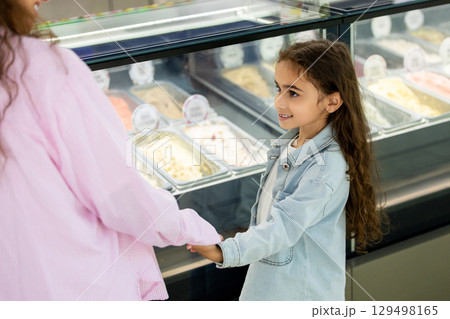 Happy family mother with child selecting gelato in bright ice cream 129498165