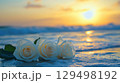 Serene Sunset Over Waves with White Roses on Shoreline Creating a Romantic Beach Atmosphere 129498192