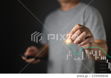 A person interacts with a digital graph, symbolizing investment, finance, or data analysis, while holding a smartphone. 129498606