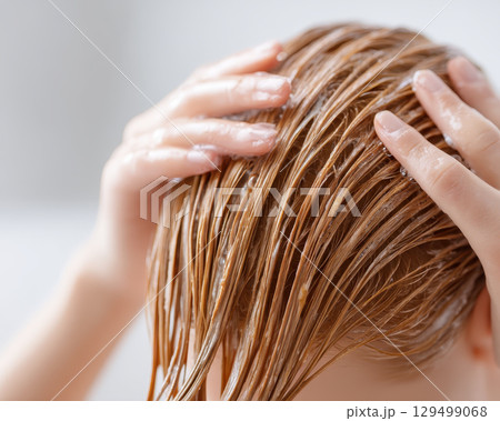 Washing hair with shampoo in beauty salon creates refreshing and clean feeling while caring for hair health and beauty in relaxing environment 129499068