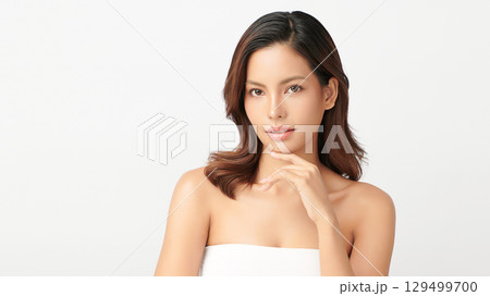 A beautiful young Asian woman with clean, fresh skin against a white background. Skincare, facial treatment, cosmetology, beauty, and spa. An elegant portrait of an Asian woman. 129499700