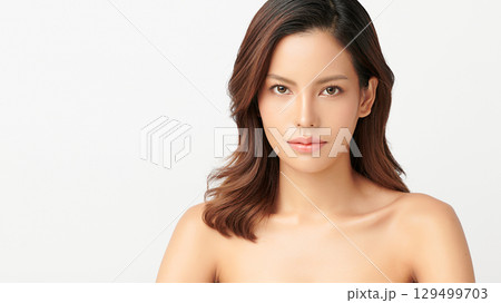 A beautiful young Asian woman with clean, fresh skin against a white background. Skincare, facial treatment, cosmetology, beauty, and spa. An elegant portrait of an Asian woman. 129499703