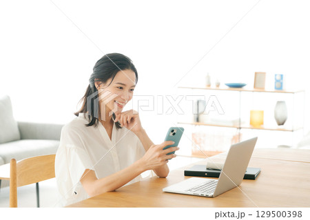 リビングでパソコンを使う女性 リビングでパソコンを使う女性 129500398