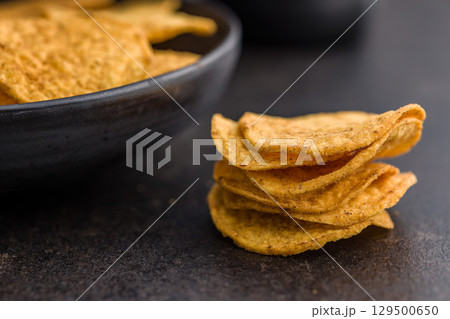 Crispy potato chips on black table. Crispy potato chips on black table. 129500650