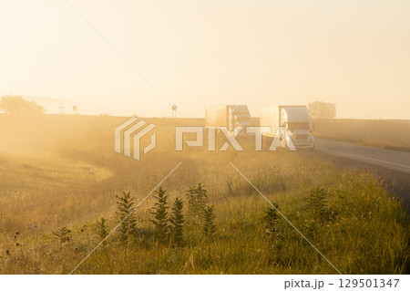 Truck driving down foggy road Truck driving down foggy road 129501347