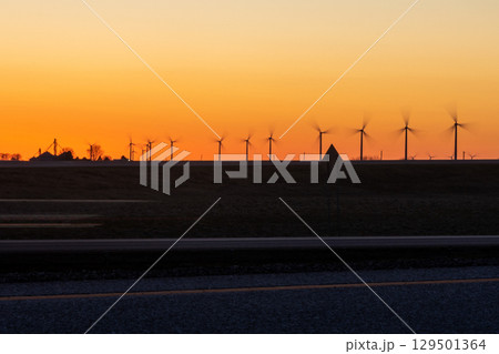 Sunset silhouette of wind turbines Sunset silhouette of wind turbines 129501364
