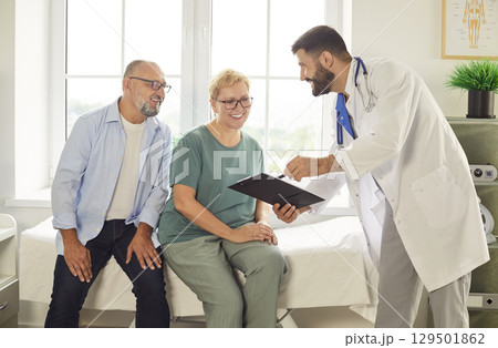 Smiling senior couple consulting with friendly doctor in bright medical office Smiling senior couple consulting with friendly doctor in bright medical office 129501862