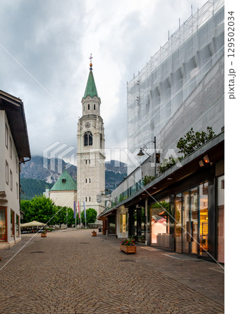 A view of the iconic church tower in the heart of Cortina d'Ampezzo. The architectural beauty of the tower stands tall against the backdrop of the surrounding Alpine scenery 129502034