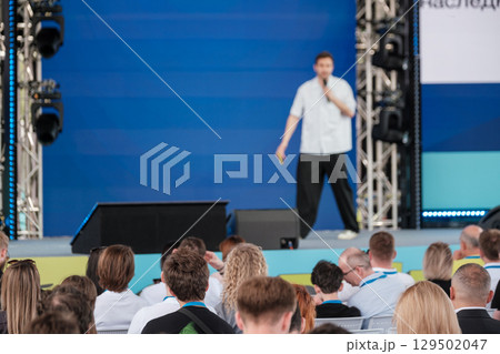 Speaker addressing audience during an engaging conference on modern stage 129502047