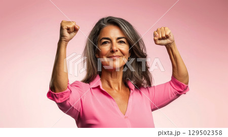 Middle aged latin american woman with raised fist of empowerment, strength and women solidarity, International Womens Day concept 129502358