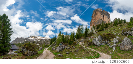 Mountain peaks around Cinque Torri in the Dolomites (Dolomiti, Dolomiten), Italy. Majestic summits partially covered in mist and clouds, with lush forests in the valleys below 129502603