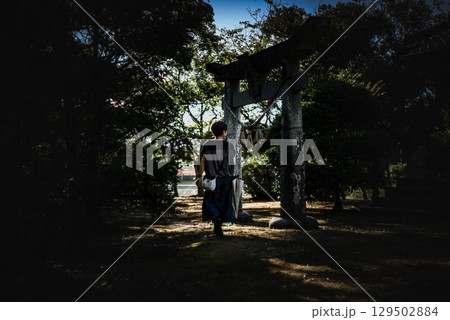 <素材>旅行で夕暮れの神社を散策する女性 <素材>旅行で夕暮れの神社を散策する女性 129502884