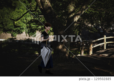 <素材>旅行で夕暮れの神社を散策する女性 <素材>旅行で夕暮れの神社を散策する女性 129502885