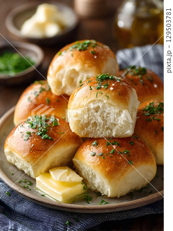 homemade bread rolls on plate with butter and herbs 129503781