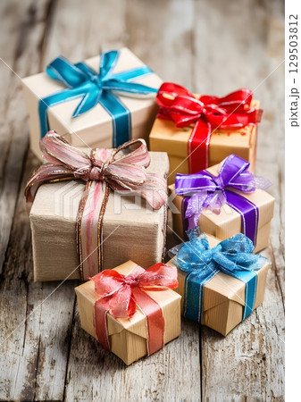 wrapped Christmas gifts with ribbons and bows on wooden floor 129503812