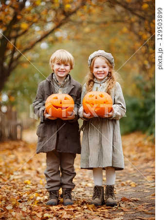 children holding jack o lanterns in autumn park 129503899