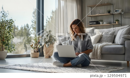 remote worker attending video call in bright living room, 129504971