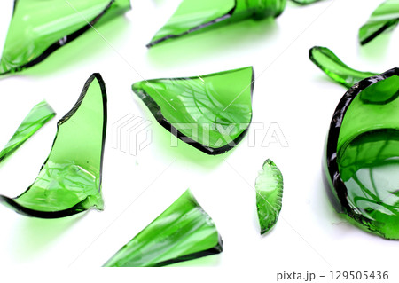 Sharp green glass shards scattered on a white background. 129505436