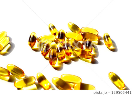 Golden fish oil capsules on white background. Golden fish oil capsules on white background. 129505441