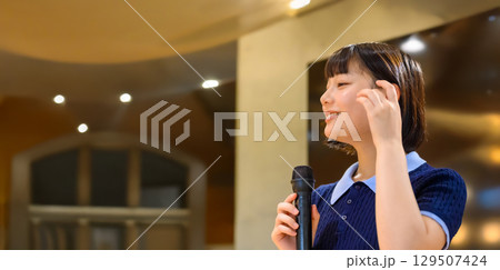 　マイクで話す女性のプレゼン風景 129507424