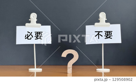 必要と不要の文字入り2つのメモの間に立体クエスチョンマーク_黒背景 129508902