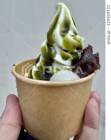 ミニカップの抹茶ソフトパフェを持つ手 129509532